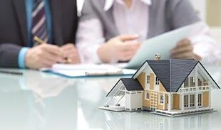 Model house resting on a desk during a real estate meeting